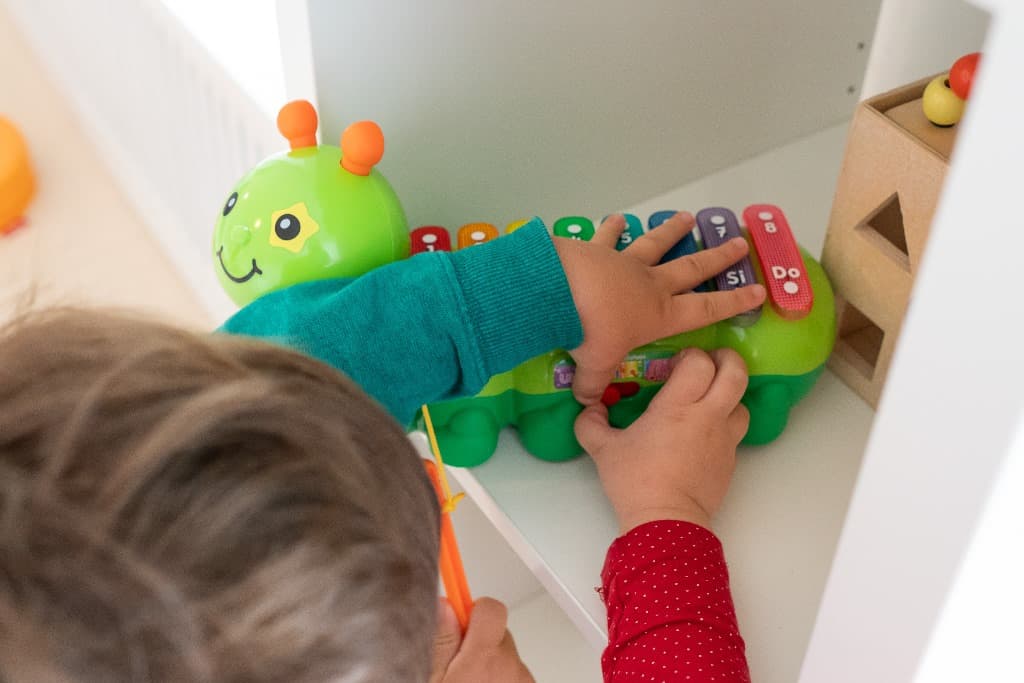 Een kind speelt op een xylofoon in de vorm van een rups